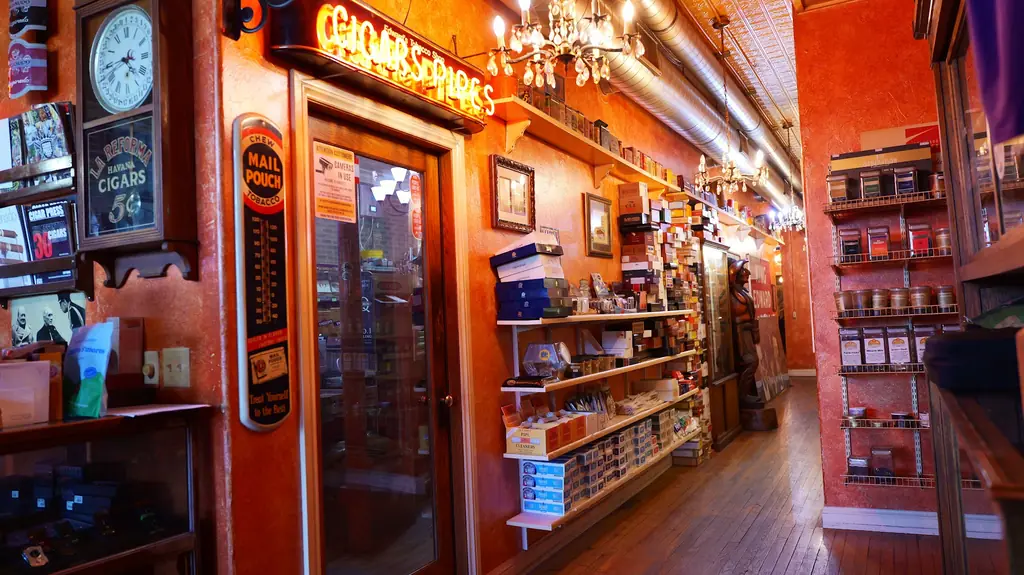 Interior of Edward's with neon cigar and pipe signage, chandeliers and a pressed tin ceiling