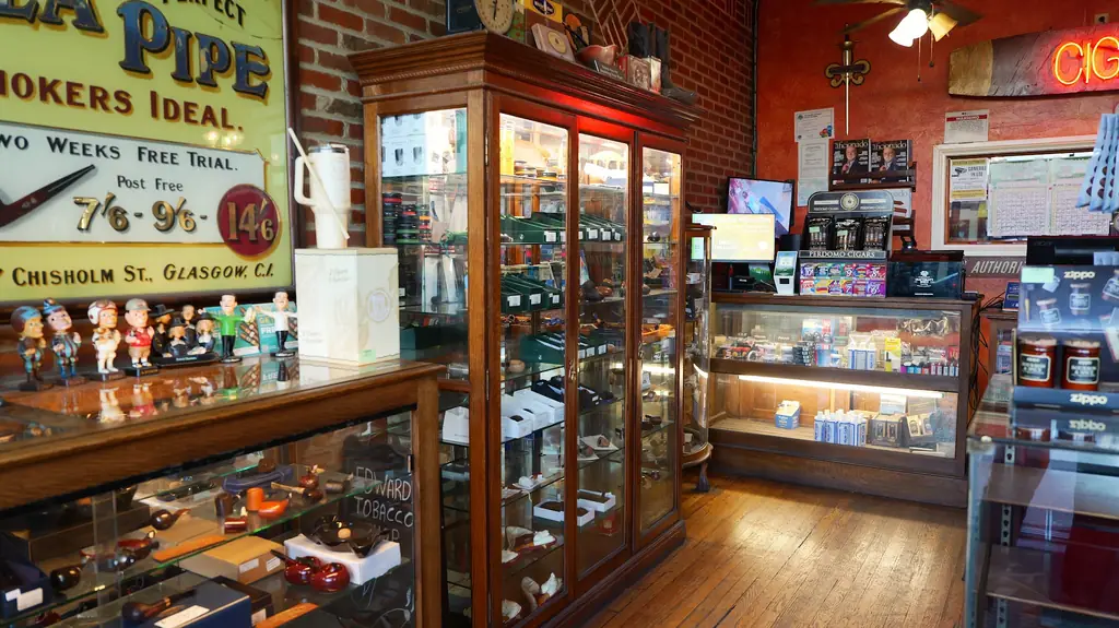Oak and glass display cabinets of briar pipes against exposed brick at Edward's Pipe and Tobacco Shop